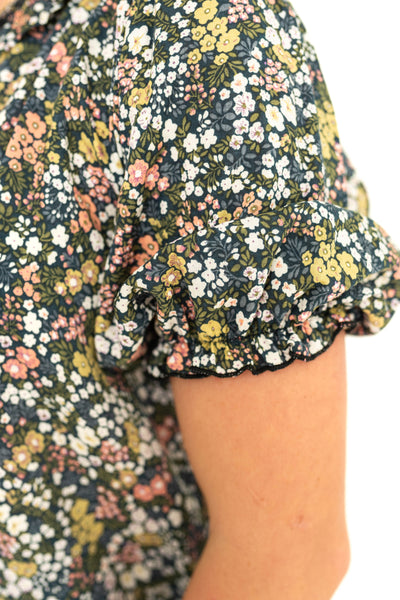 Sleeve view of a short sleeve navy floral print top.