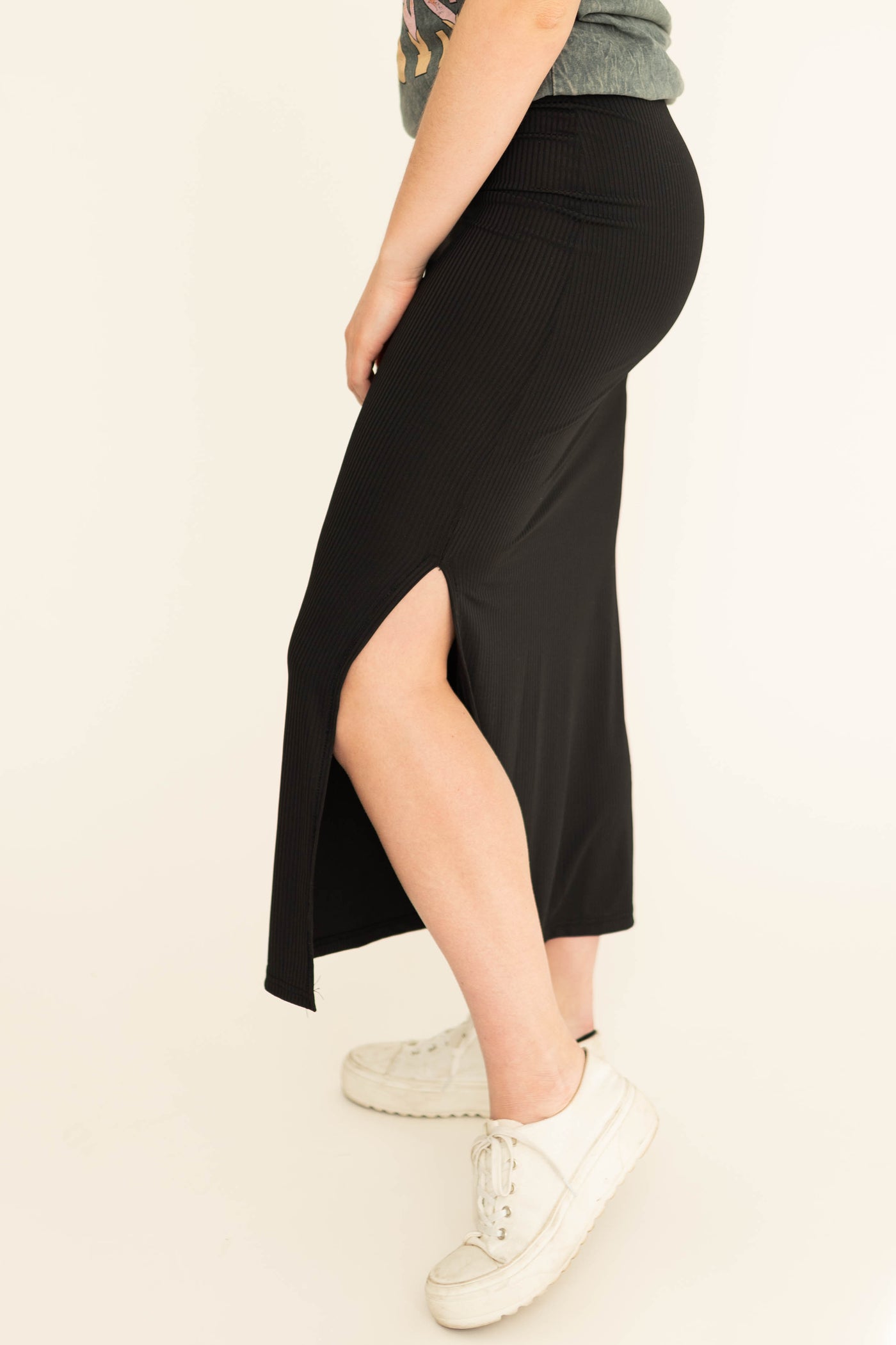 Side view of a black fitted skirt with side slit.  Come in small to 3x.