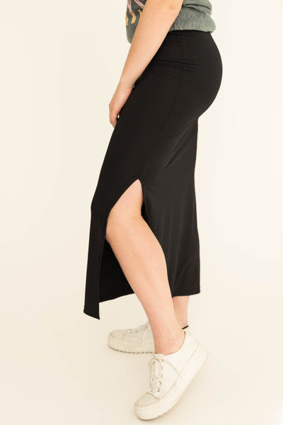 Side view of a black fitted skirt with side slit.  Come in small to 3x.