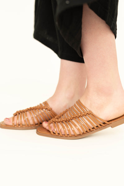 Side view of tan colored strappy slip on sandals. 