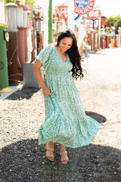 Front view of a short sleeve kelly green dress with a v-neck and tiered skirt