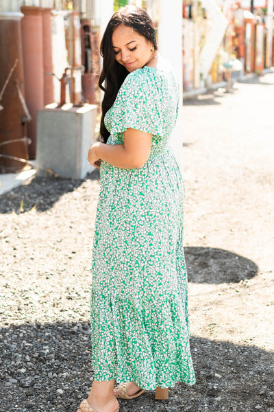 Side view of a short sleeve kelly green dress with a v-neck and tiered skirt