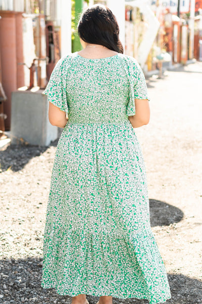 Back view of a short sleeve kelly green dress with a v-neck and tiered skirt