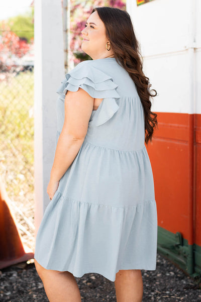Side of view of plus size blue dress with tiers and ruffles on sleeves