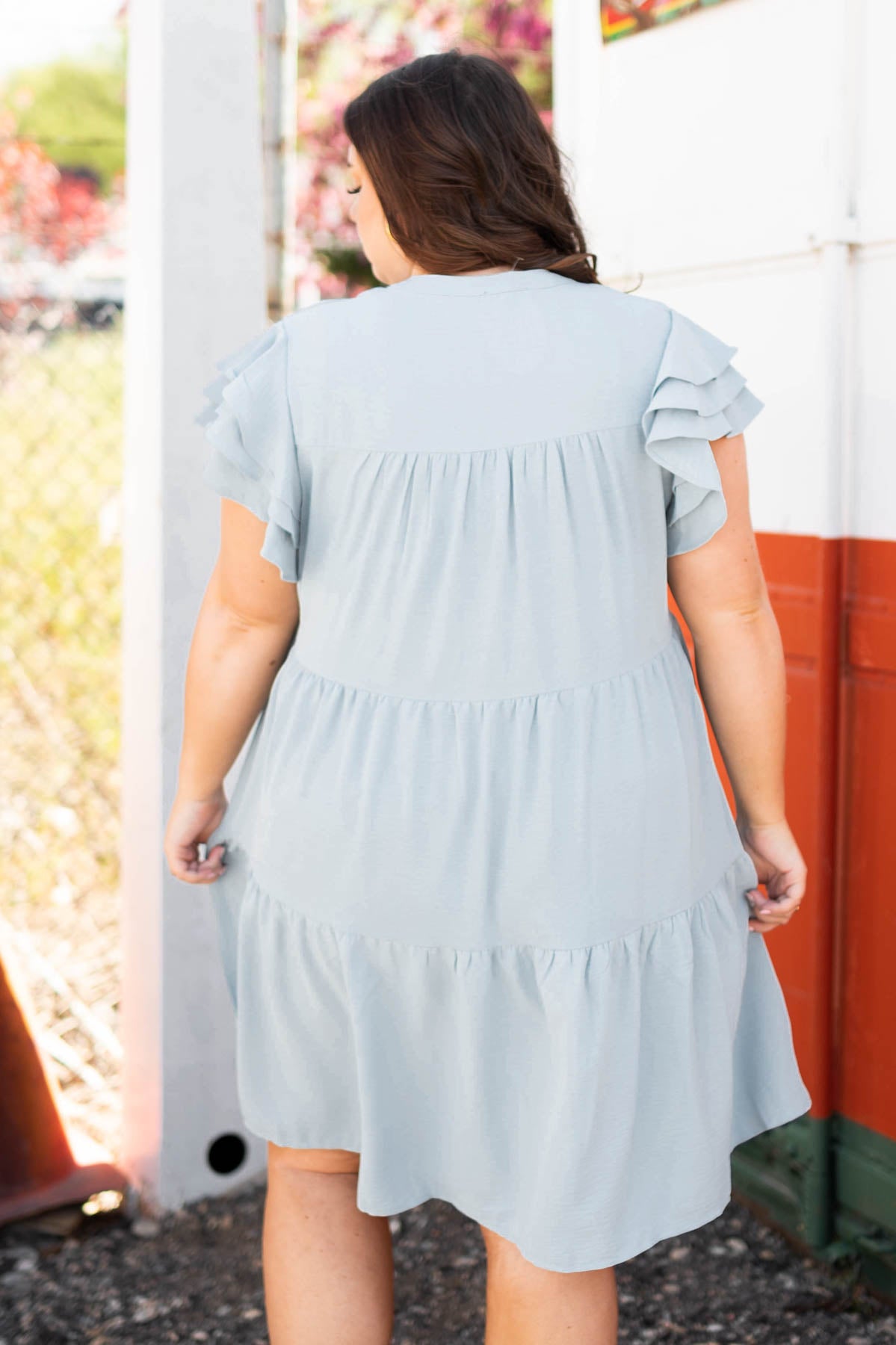Back view of plus size blue dress with tiers and ruffles on sleeves