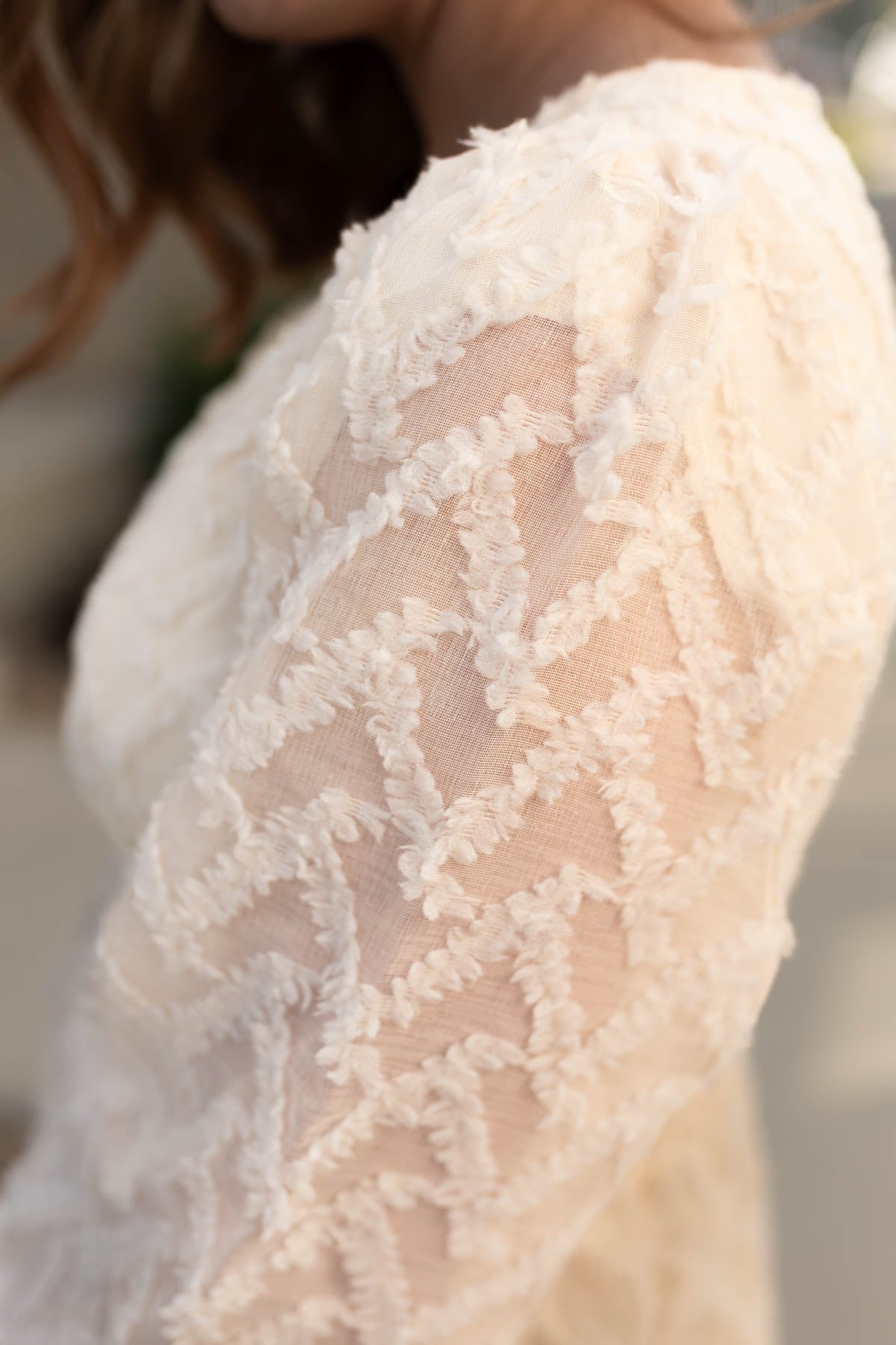 Close up on the fabric of a cream textured dress