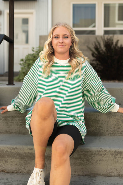 Long sleeve green top with white stripes and cuffs