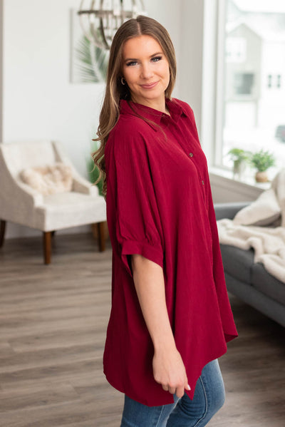 Side view of a burgundy button down blouse