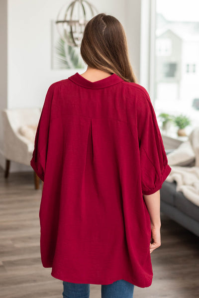 Back view of an over sized burgundy button down blouse
