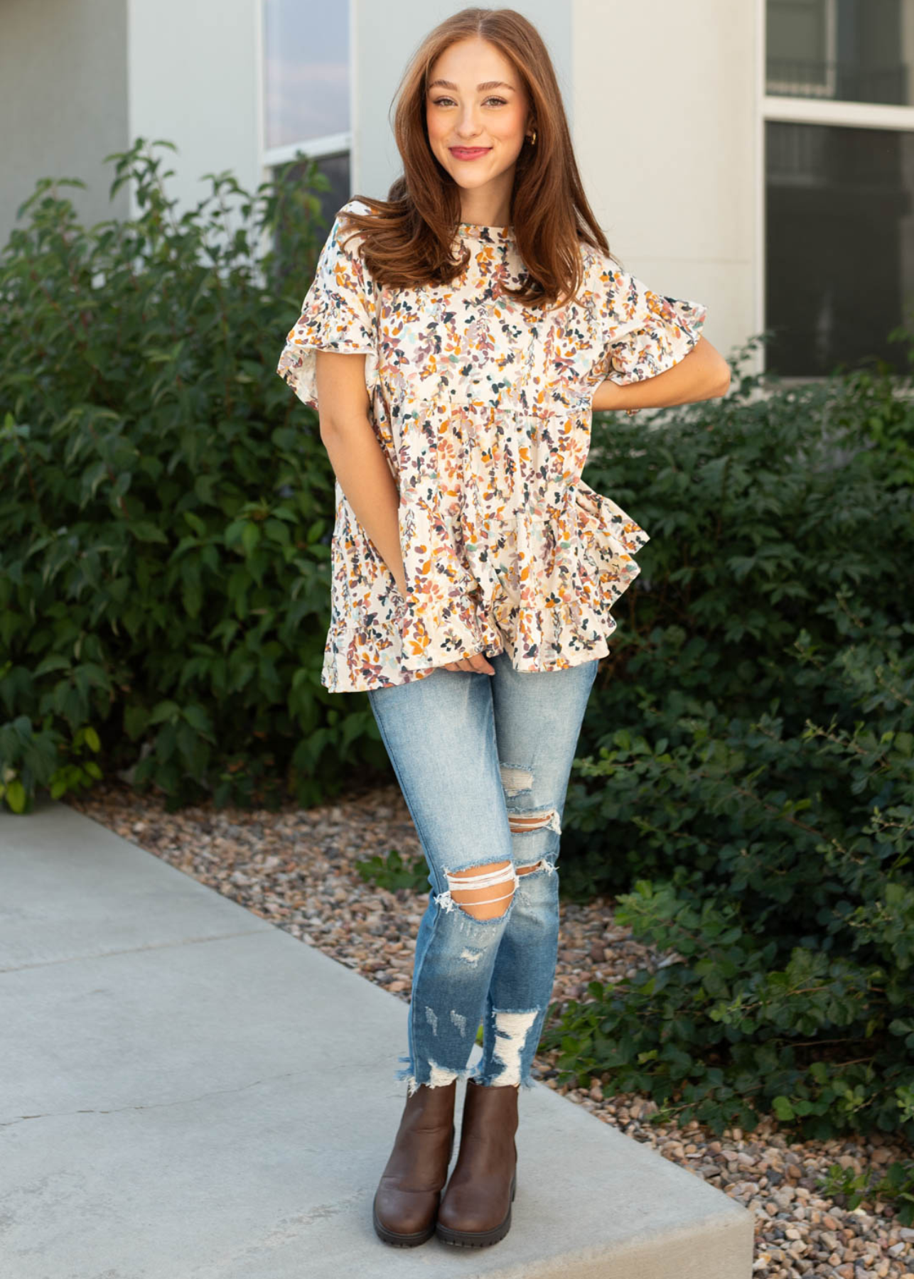 Short sleeve cream top with a floral top and ruffle at the hem