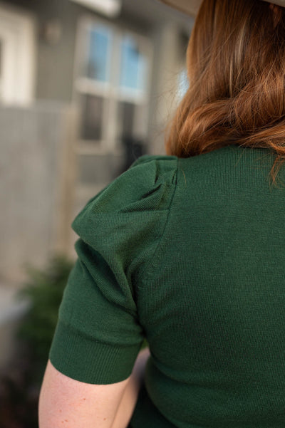 Sleeve view of a dark green top
