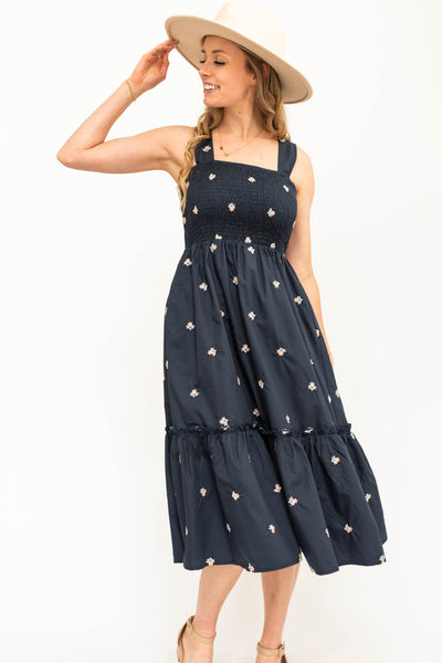 Navy blue sundress, elastic straps, smocked bodice with white daisy floral print.