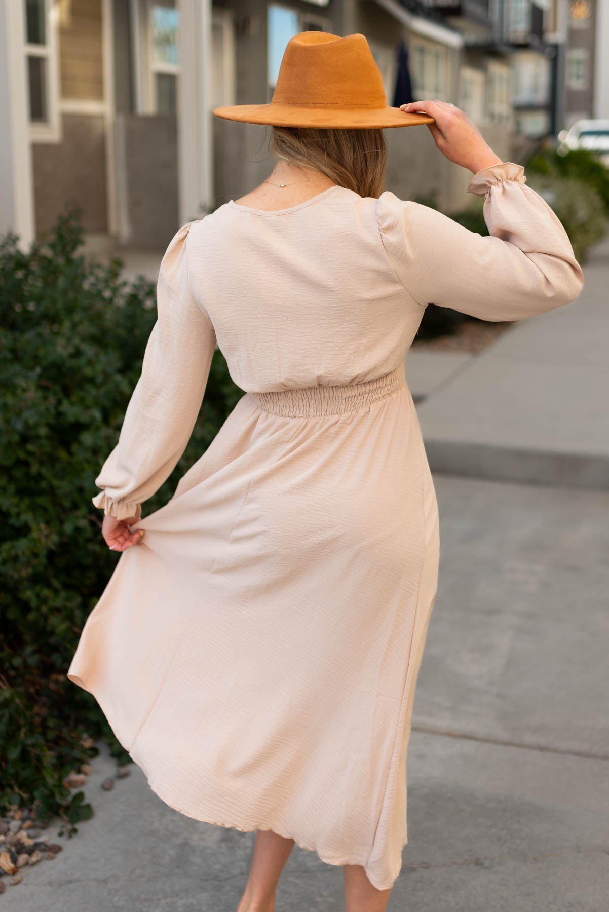 Back view of a beige v-neck dress