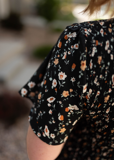 Sleeve of a black floral dress