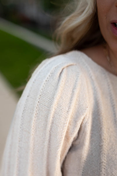 Close up of the sweater pattern on a taupe sweater