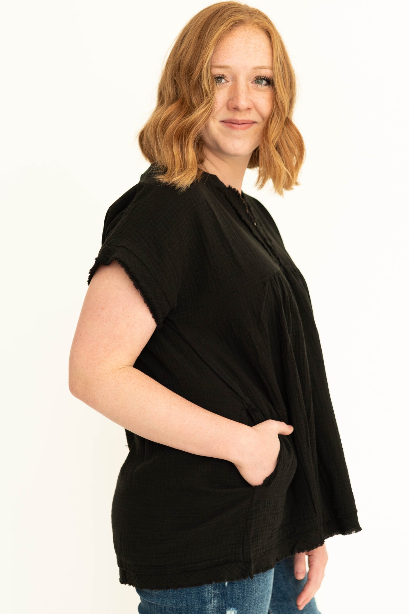 Side view of a black gauze top with pockets