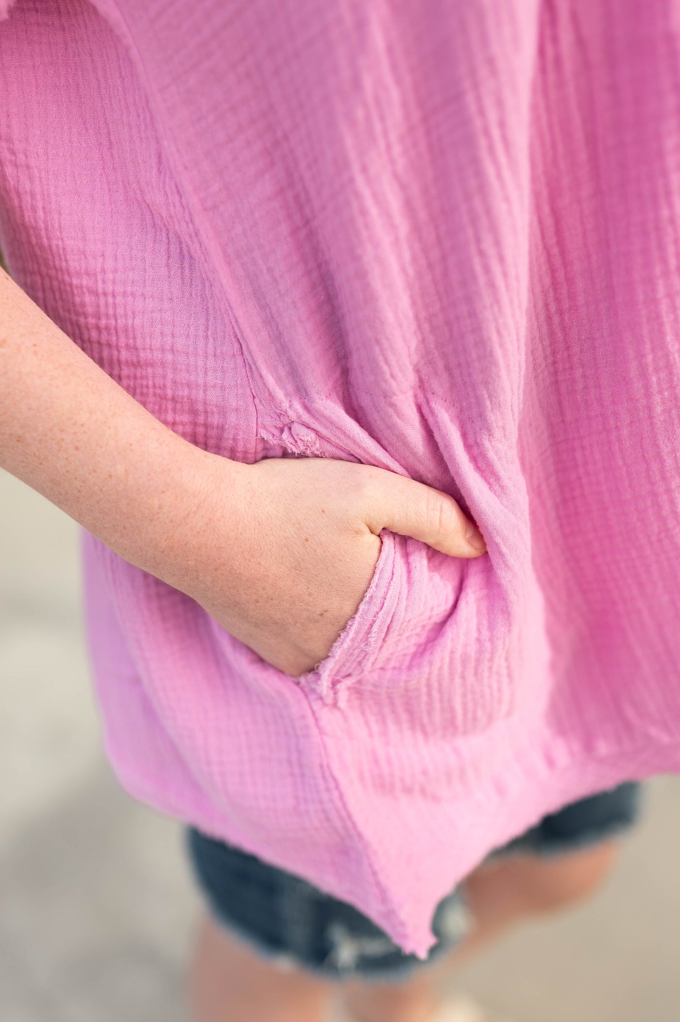Pocket detail of a mauve short sleeve top with a v-neck.