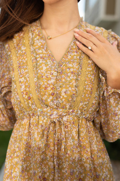 Neckline and floral pattern of a golden dress