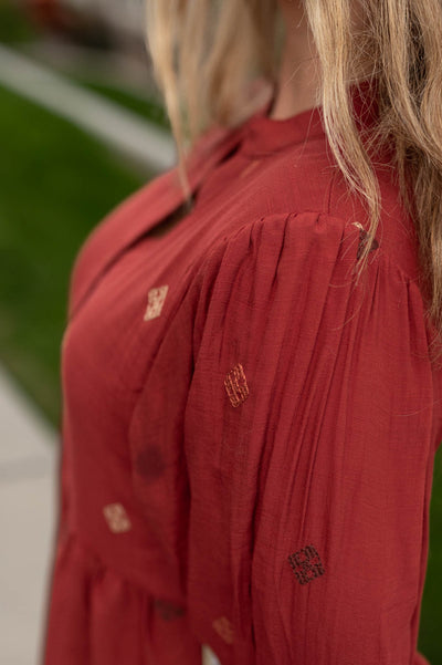 Close up of the fabric on a dark terracotta dress