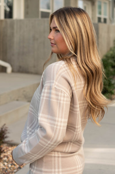 Side view of a taupe plaid sweater