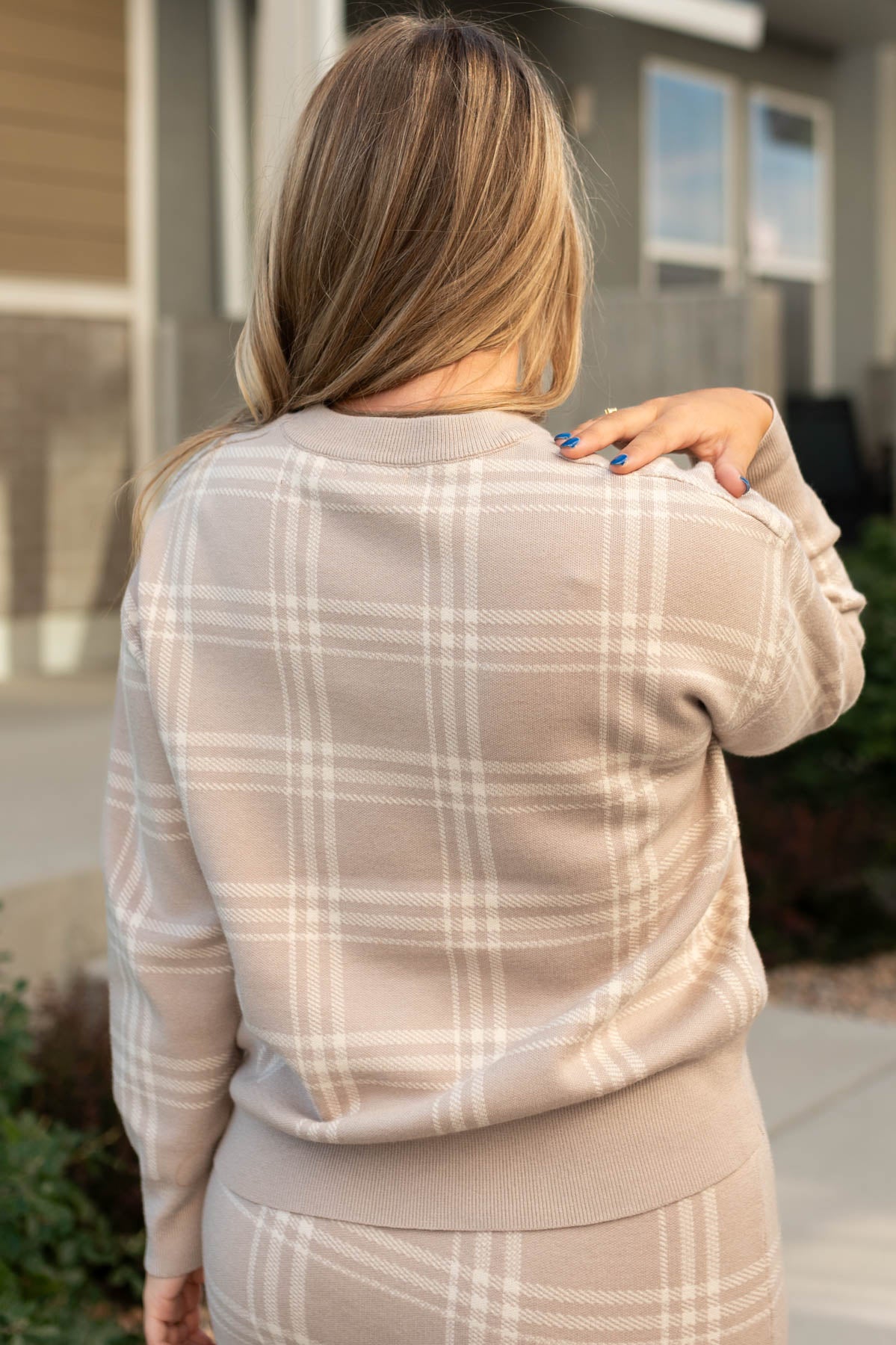 Back view of a taupe plaid sweater