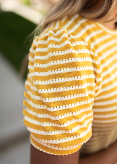 Sleeve view of a mustard top