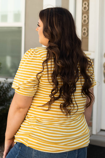 Back view of a plus size striped short sleeve mustard top