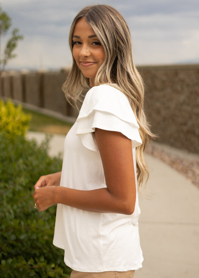 Side view of a white top with ruffle sleeves