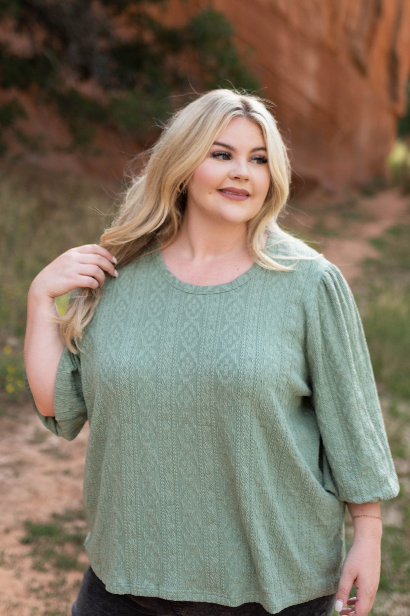 Plus size sage top with 3/4 sleeves and pattern in the fabric