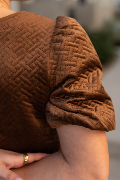 Close up of the sleeve of a chocolate dress