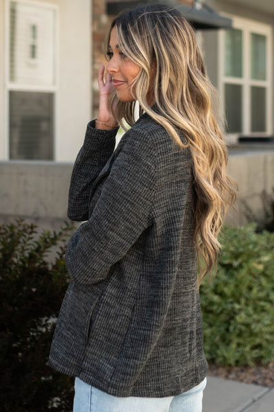 Side view of a charcoal blazer with pockets 