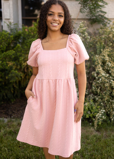 Front view of a dusty pink dress with a square neck