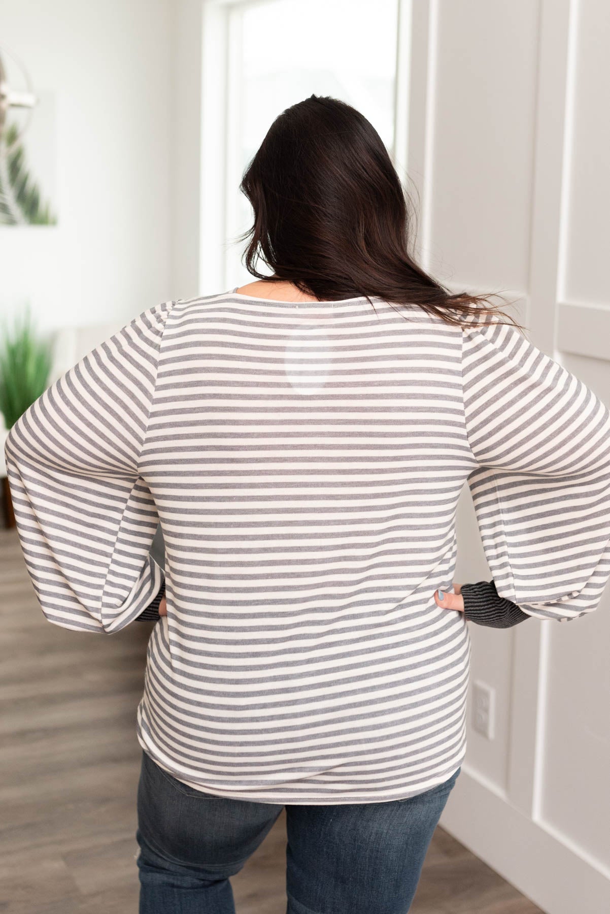 Back view of a plus size grey striped long sleeve top