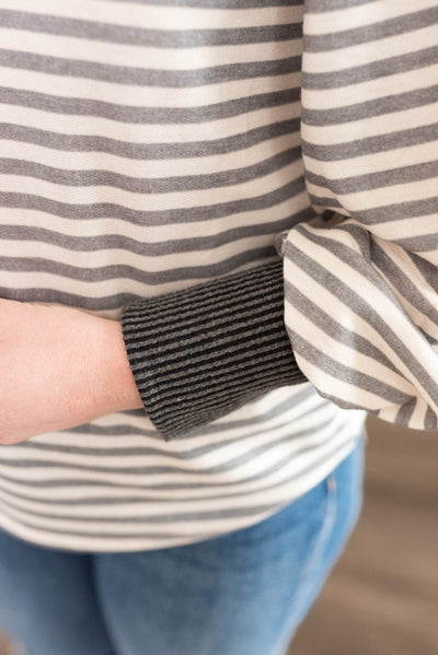 Close up of the grey cuffs on a grey striped long sleeve top