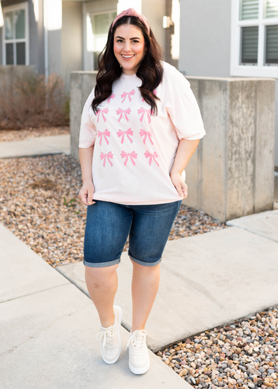 Front view of the plus size light pink ribbons graphic tee