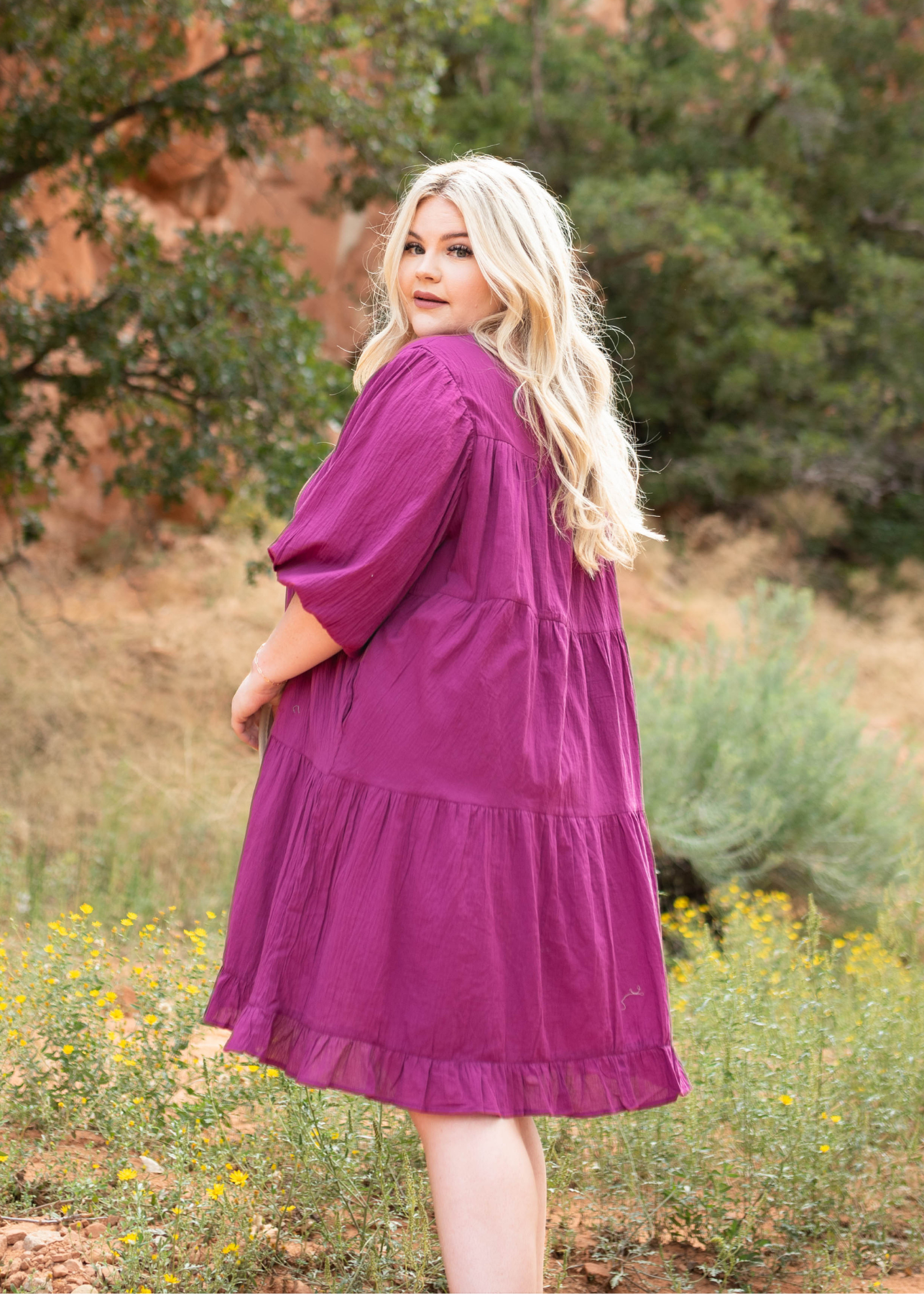 Side view of a plus size berry dress with pockets