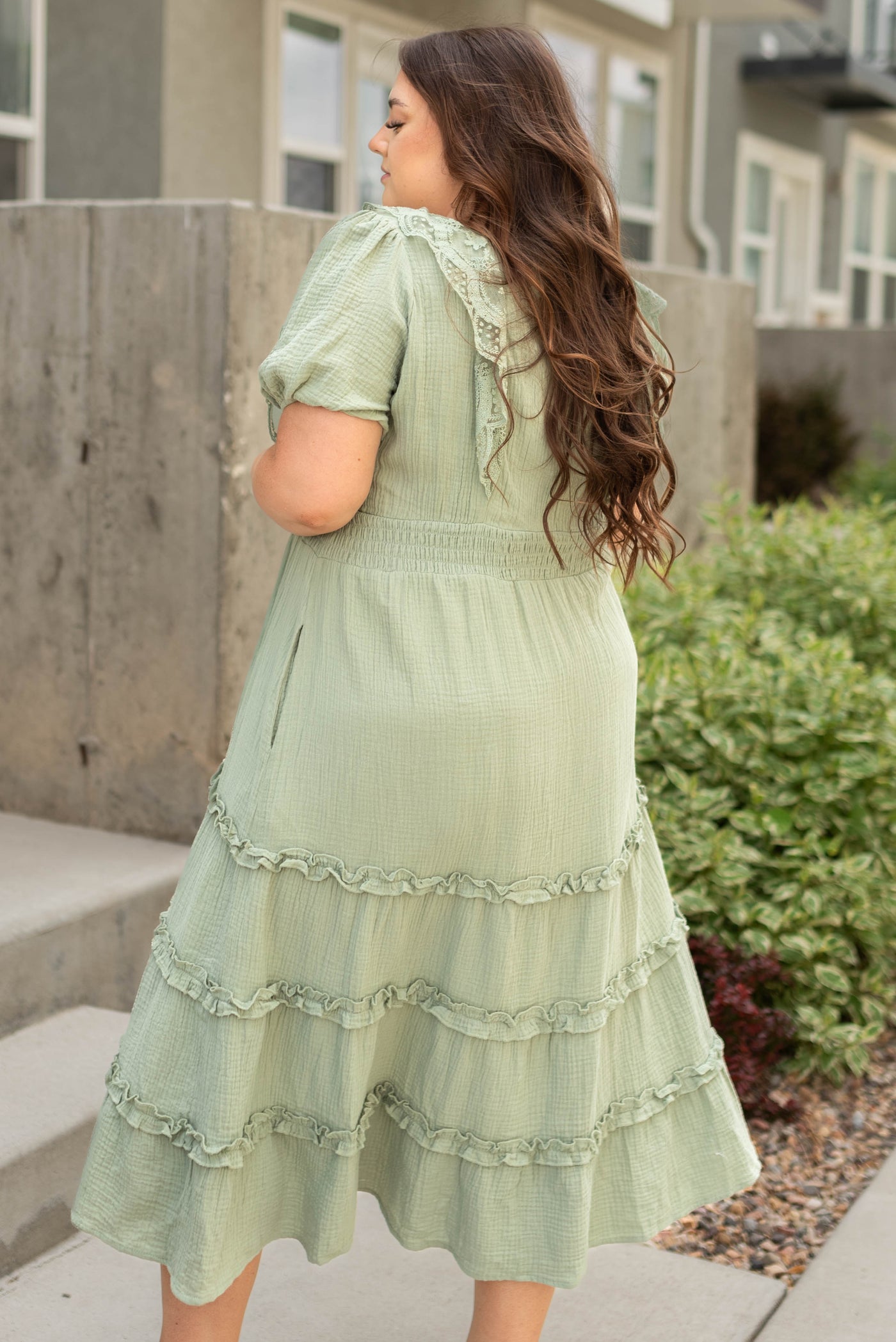Side view of a plus size sage dress with an elastic waist
