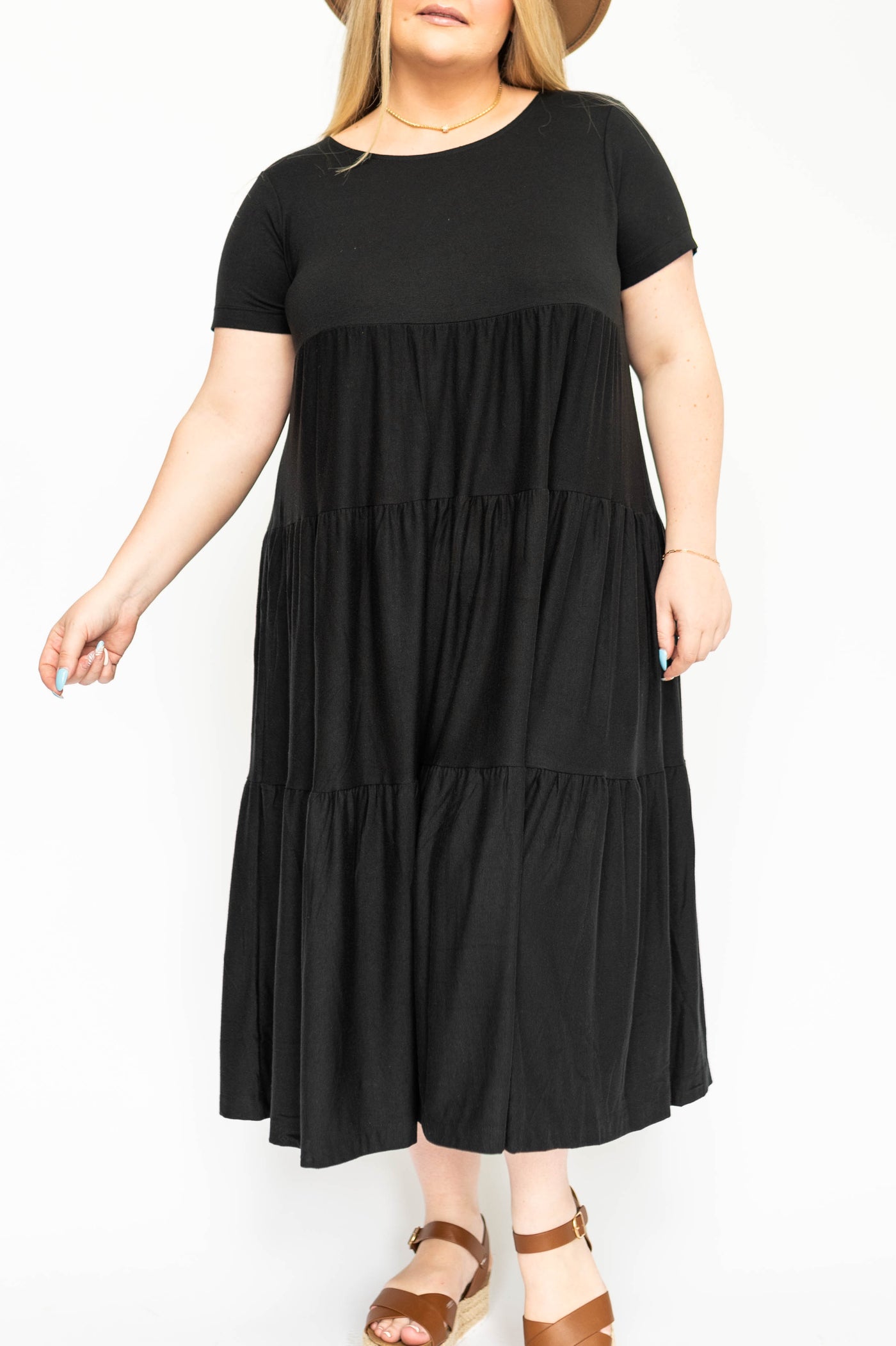 Front view of a plus size black tiered dress