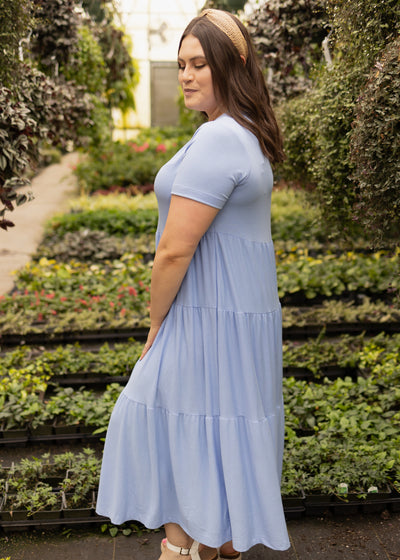 Side view of a plus size blue knit dress with short sleeves