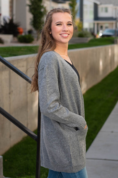 Side view of a long sleeve grey cardigan