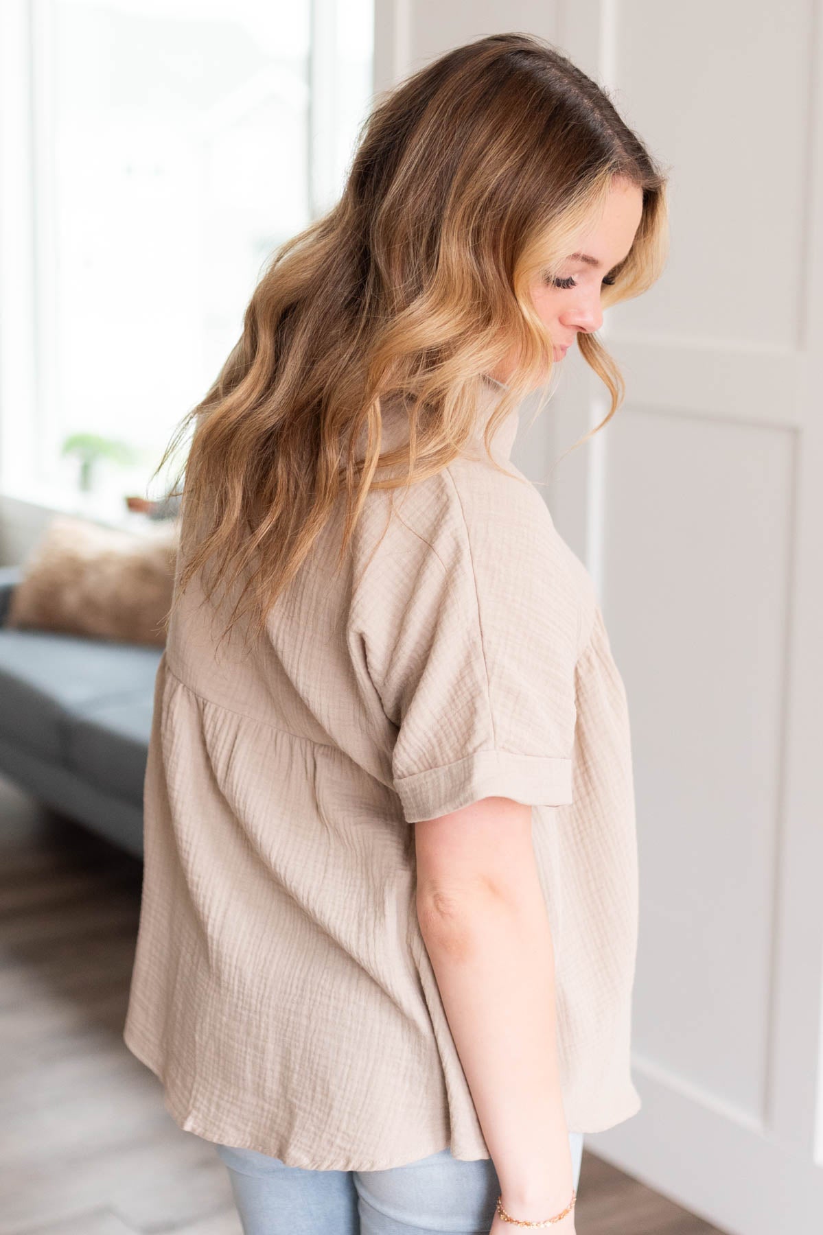 Side view of the taupe button down top