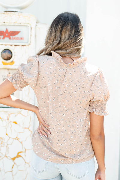 Back view of a taupe floral top