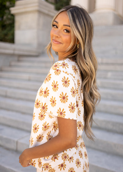 Side view of a knit cream daisy top