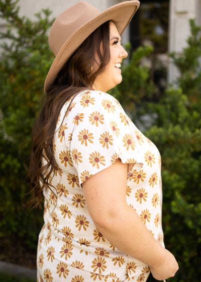 Side view of a plus size cream daisy top