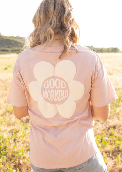 Pink top  with short sleeves and white daisy on back