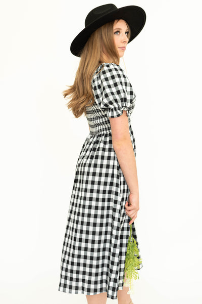 Side view of a black gingham dress with short sleeves