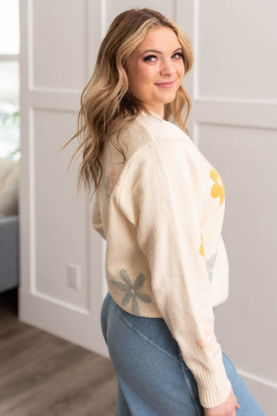 Side view of a cream floral sweater