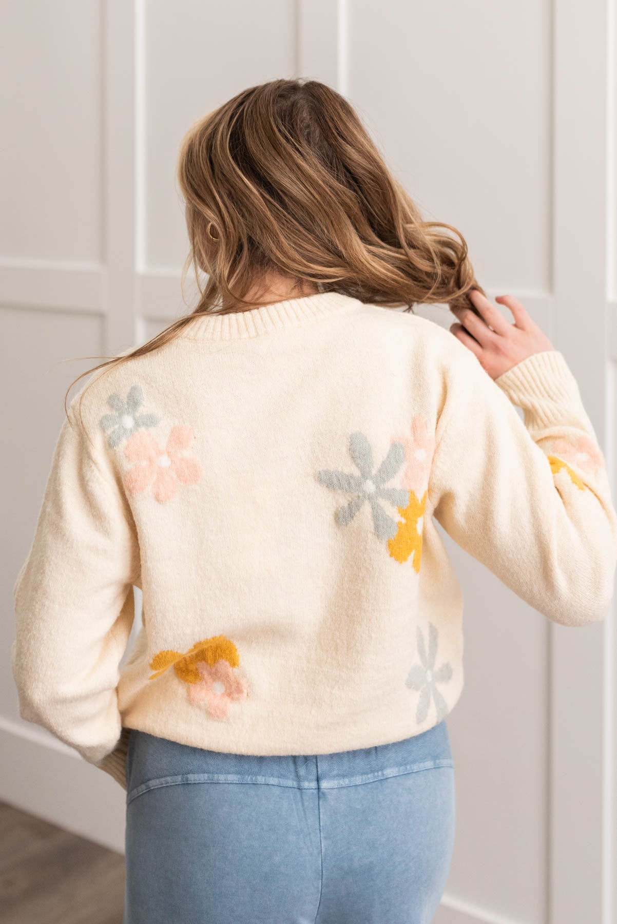 Back view of a cream floral sweater