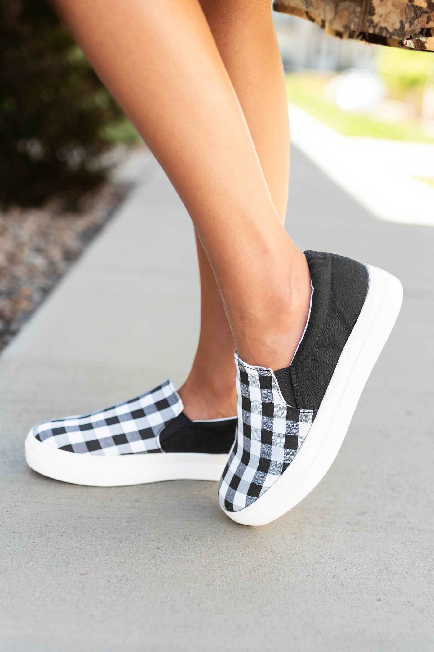 Side view of black gingham slip on shoes