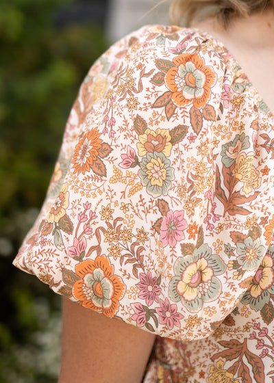 Floral sleeve of a taupe dress